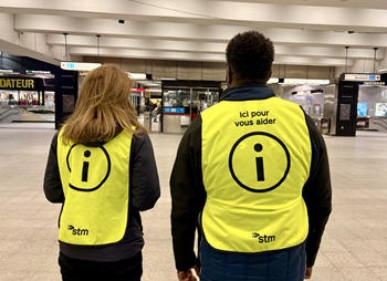 Deux personnes portant un dossard portant le message "ici pour vous aider"