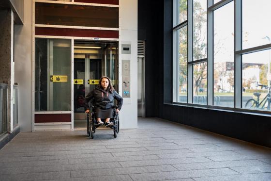 Photo d’une femme en fauteuil roulant qui sort d’un ascenseur dans une station de métro.