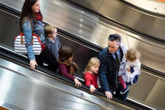 Photo d’une famille qui descend un escalier mécanique dans le métro.