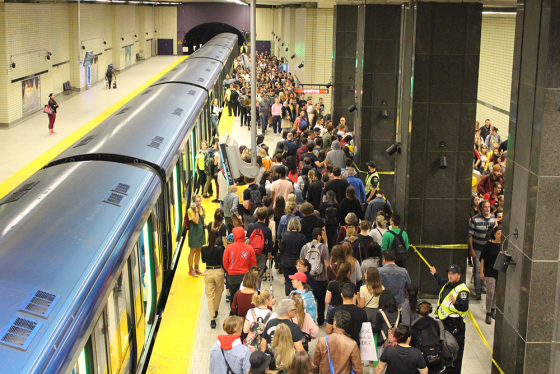 Photo métro en staton et quai bondé de clientèle. 