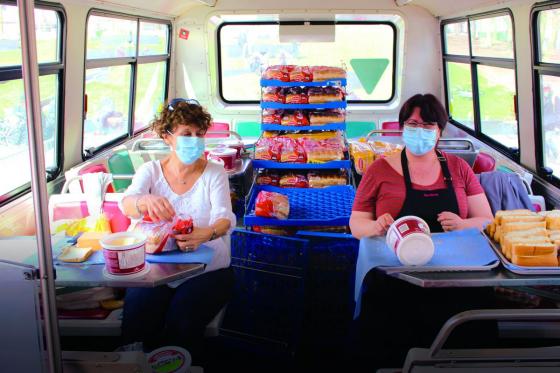 Photo de l'intérieur du Réchaud-bus et des employés en train de préparer le repas.