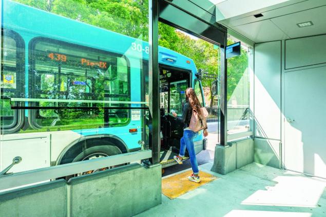 Une cliente monte à bord d'un bus depuis un abri SRB Pie-IX.